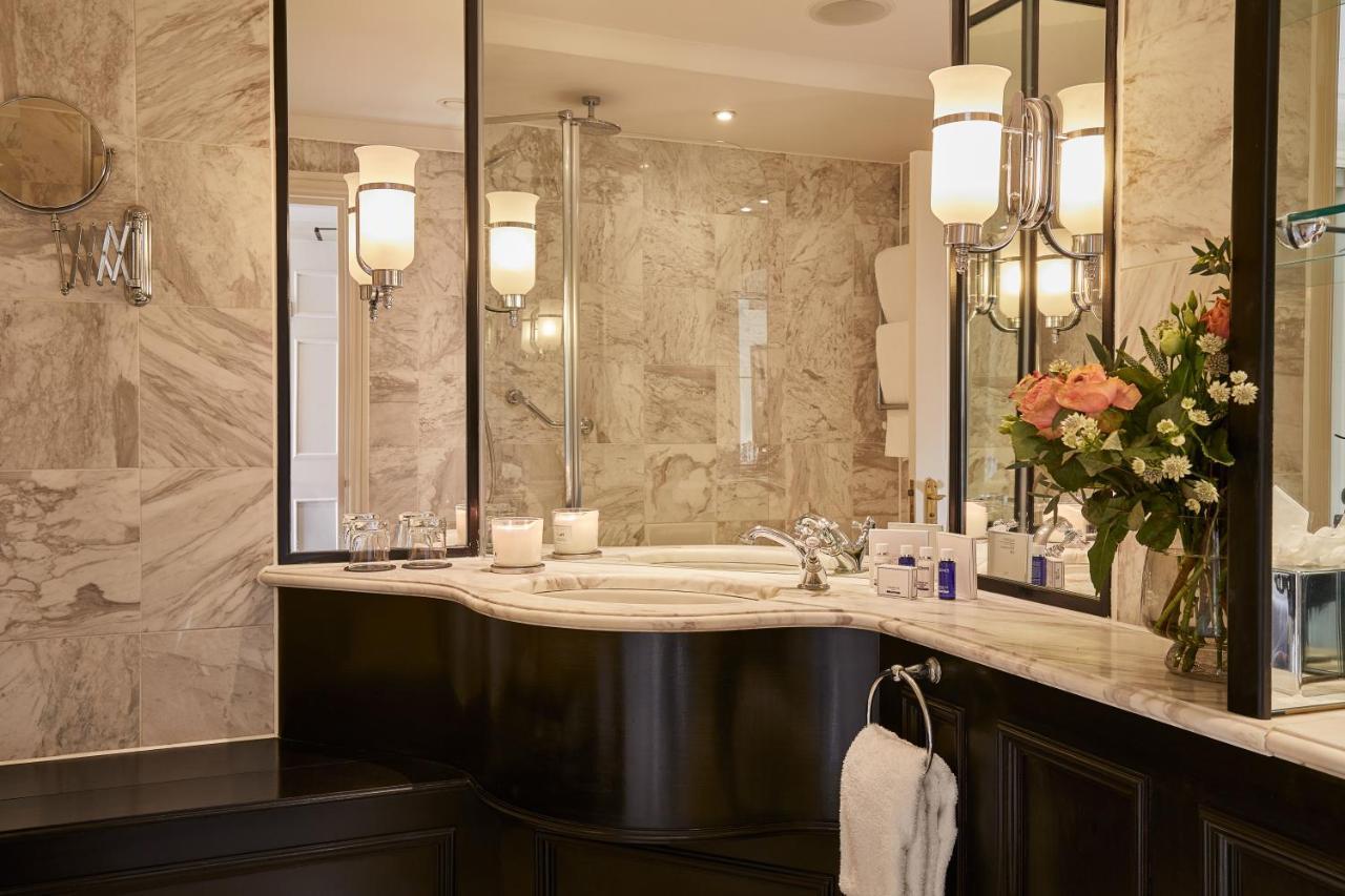 Macdonald Bath Spa Hotel Екстер'єр фото The photo shows a luxurious bathroom featuring elegant design elements. There is a curved marble countertop with a sink, complemented by stylish silver fixtures. The walls are adorned with light-colored marble, creating a sophisticated ambiance. Seve