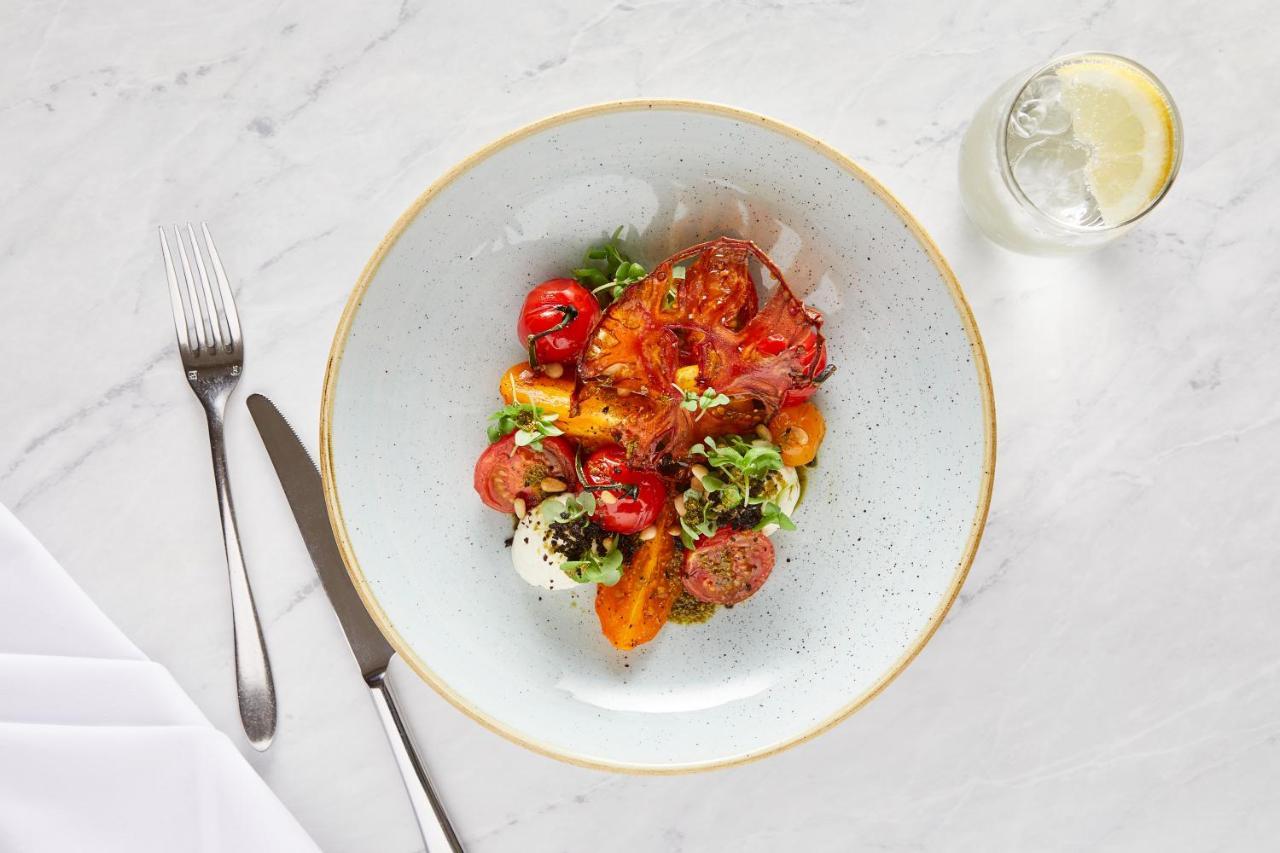 Macdonald Bath Spa Hotel Екстер'єр фото The photo shows a beautifully arranged plate of food. The dish features a mix of colorful ingredients, including roasted or grilled vegetables, likely bell peppers and tomatoes, along with fresh greens. There are also some circular slices of another 