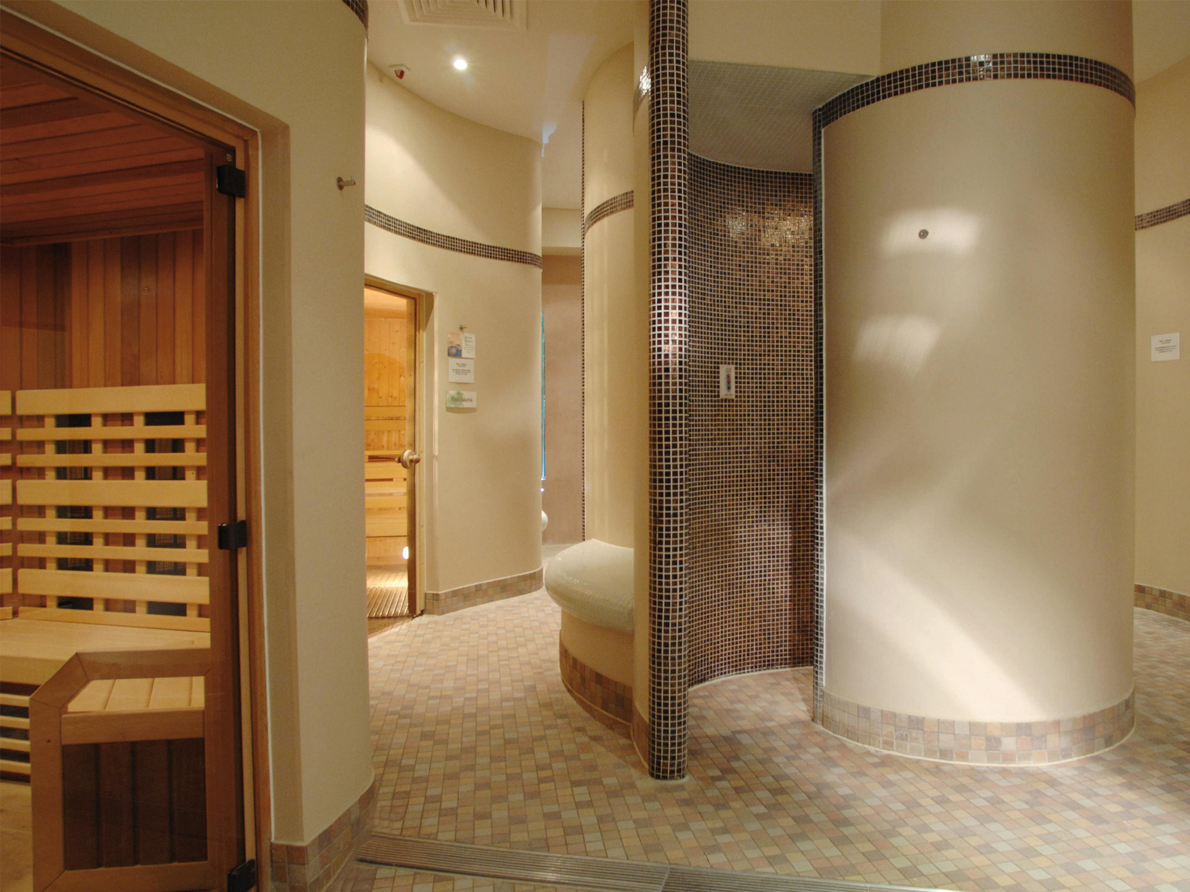Macdonald Bath Spa Hotel Екстер'єр фото The photo shows a contemporary spa area featuring a sauna and relaxation space. The interior has smooth, rounded walls and tiled surfaces, creating a calming atmosphere. On one side, there's a wooden sauna with slatted seating. Nearby, a curved wall 