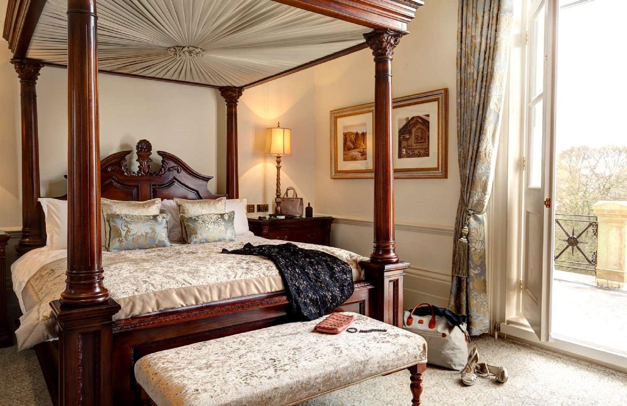 Macdonald Bath Spa Hotel Екстер'єр фото The photo depicts a beautifully designed bedroom featuring a four-poster bed with a decorative canopy. The bed is dressed with elegant bedding and several patterned pillows. Adjacent to the bed, there is a matching wooden nightstand with a stylish la